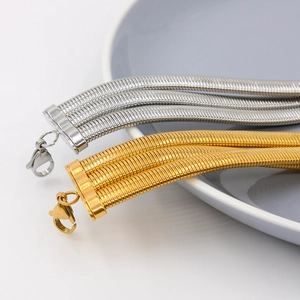 Detail of multi-strand gold and silver snake bone necklaces with lobster clasp closure