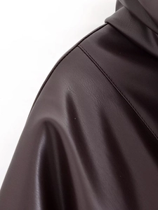 Détail d'une veste en cuir marron foncé montrant les coutures de l'épaule et le grain du cuir