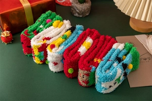 Détail de chaussettes de Noël en polaire corail douce avec pompons 3D en couleurs festives