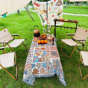 Close-up of bohemian knit picnic blanket with tassels used as a stylish outdoor tablecloth