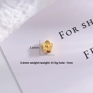 Macro detail of 3.6mm gold flower bead with matte finish and 1mm hole for jewelry DIY