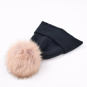 Women's black ribbed knit winter hat with a fluffy pink faux fur pom-pom detail