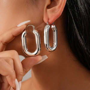 Polished silver U-shaped oval hoop earrings shown on a model for a stylish minimalist look
