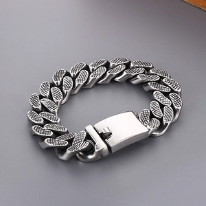 Detailed macro shot of vintage silver punk Cuban link bracelet with textured rivet patterns