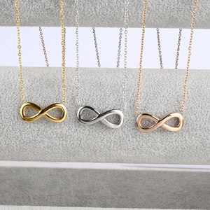 Tres collares con símbolo de infinito en acabados oro, plata y oro rosa sobre terciopelo