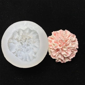 White silicone flower mold and pink carnation resin artwork on black background
