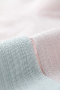 Macro shot of breathable lyocell and silk mesh texture in light blue and pink colors