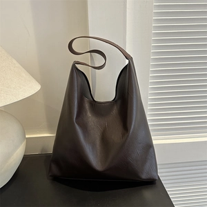 Minimalist coffee brown large capacity leather hobo tote bag in a home decor setting