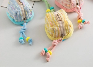 Détail de pochettes à écouteurs en maille colorée avec zips et perles décoratives