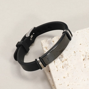 Dettaglio di un bracciale in silicone nero con una piastra decorativa in acciaio inossidabile