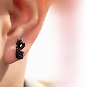 Vue détaillée d'une boucle d'oreille dragon noir montrant les textures des écailles