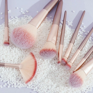 Flat lay of 8-piece makeup brush set with rose gold handles and pink-white gradient bristles