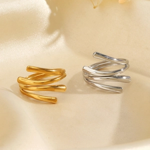 Stacked 18K gold and silver stainless steel spiral rings on soft silk fabric background