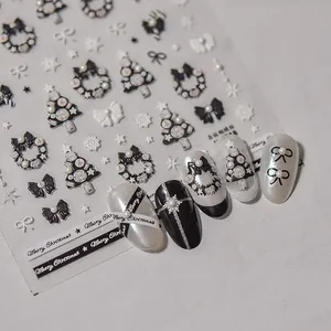 Vue macro d'autocollants 3D pour ongles de Noël avec motifs de nœuds et sapins noir et blanc