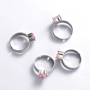 Detail view of four silver stainless steel rings with pink heart-shaped gemstones
