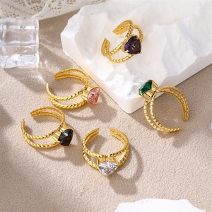 Detail of five stackable gold twisted rings featuring heart-shaped zircon stones