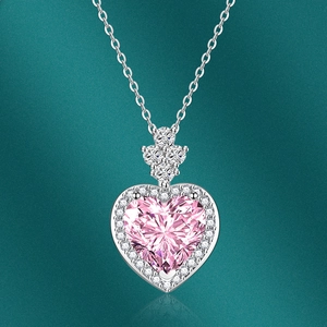 Macro di una collana d'argento con gemma a cuore rosa sfaccettata e piccoli diamanti