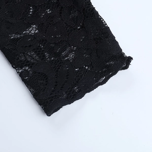Gros plan détaillé de la texture de dentelle florale évidée sur une mini robe noire