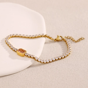 Detail view of 18K gold plated bracelet with pink rectangular stone and white zircons