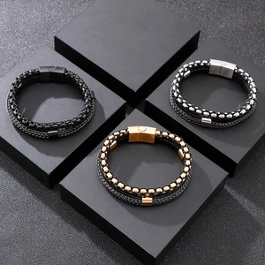 Detail of multi-layer leather braided bracelets with steel chain and magnetic buckle