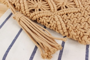 Close-up of bohemian woven cotton rope beach bag with decorative long fringe detail
