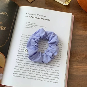 Detail of purple fabric scrunchie with From Sheep label on an open vintage book