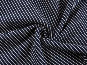 Gros plan d'un tissu tricoté rayé bleu et blanc avec texture drapée en spirale douce