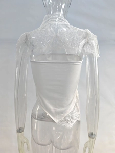 Détail du haut bustier blanc montrant la dentelle délicate et l'ourlet asymétrique au dos