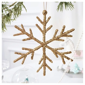 Close-up of sparkling gold glitter snowflake ornament hanging on a green Christmas tree