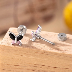 Elegant butterfly screw back stud earrings with colorful gemstones on a wood surface