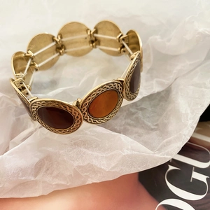 Macro detail of vintage gold leopard print elastic bracelet with amber resin inlays