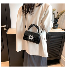 Détail du sac à main noir motif crocodile avec boucle carrée ornée de strass étincelants