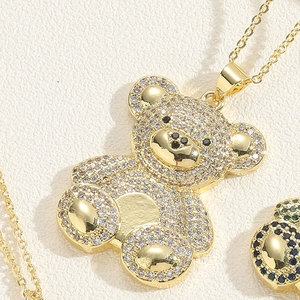 Macro shot of gold teddy bear pendant with clear zircon micro-paving and black gem eyes