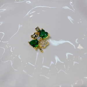 Golden four-leaf clover pendant featuring green heart-shaped gems and small sparkling crystals