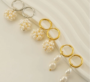 Détail de créoles plaquées or 18 carats et argent avec perles baroques sur fond beige