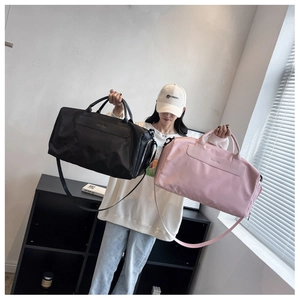 Black and pink large travel bags held by a model to show size and portable style