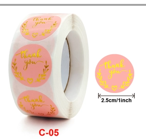 Detail of pink round thank you sticker with gold foil wreath and 1 inch size marking