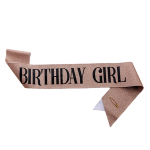 Détail de l'écharpe d'anniversaire pailletée or rose avec une épingle de sûreté dorée