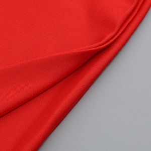 Macro shot of red ribbed knit fabric texture showing professional luxury garment quality
