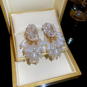 Detail of luxury fringe earrings with pearls and crystals in a gold gift box