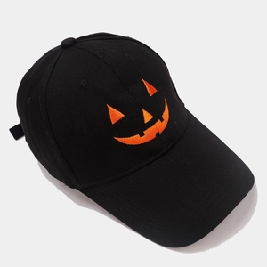 Close-up of orange Jack-o'-lantern embroidery on a black cotton twill baseball cap