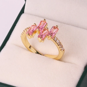 Detailed macro view of gold-plated ring featuring pink rectangular zircon in a jewelry box