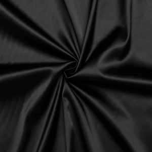 Close-up of black satin dress fabric showing luxurious silk texture and elegant draping