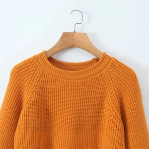 Pull en maille orange à col rond et manches raglan au style minimaliste classique