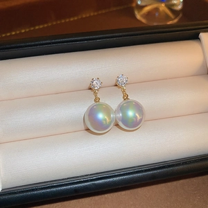 Detailed view of elegant pearl earrings with sparkling crystals in a satin jewelry box