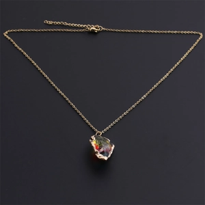 Macro shot of gold-plated chain necklace with colorful resin crystal and lobster clasp