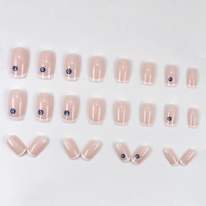 Faux ongles French blancs avec motifs œil bleu sur base rose nude naturelle