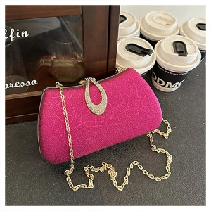 Detailed macro shot of a rose red hard shell evening bag with rhinestone water drop clasp
