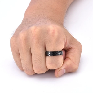 Detail of black hammered stainless steel ring with a minimalist textured surface finish