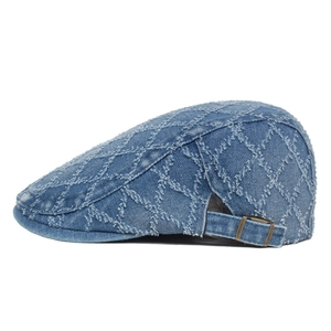 Detail view of denim beret featuring diamond pattern fringe and adjustable metal buckle